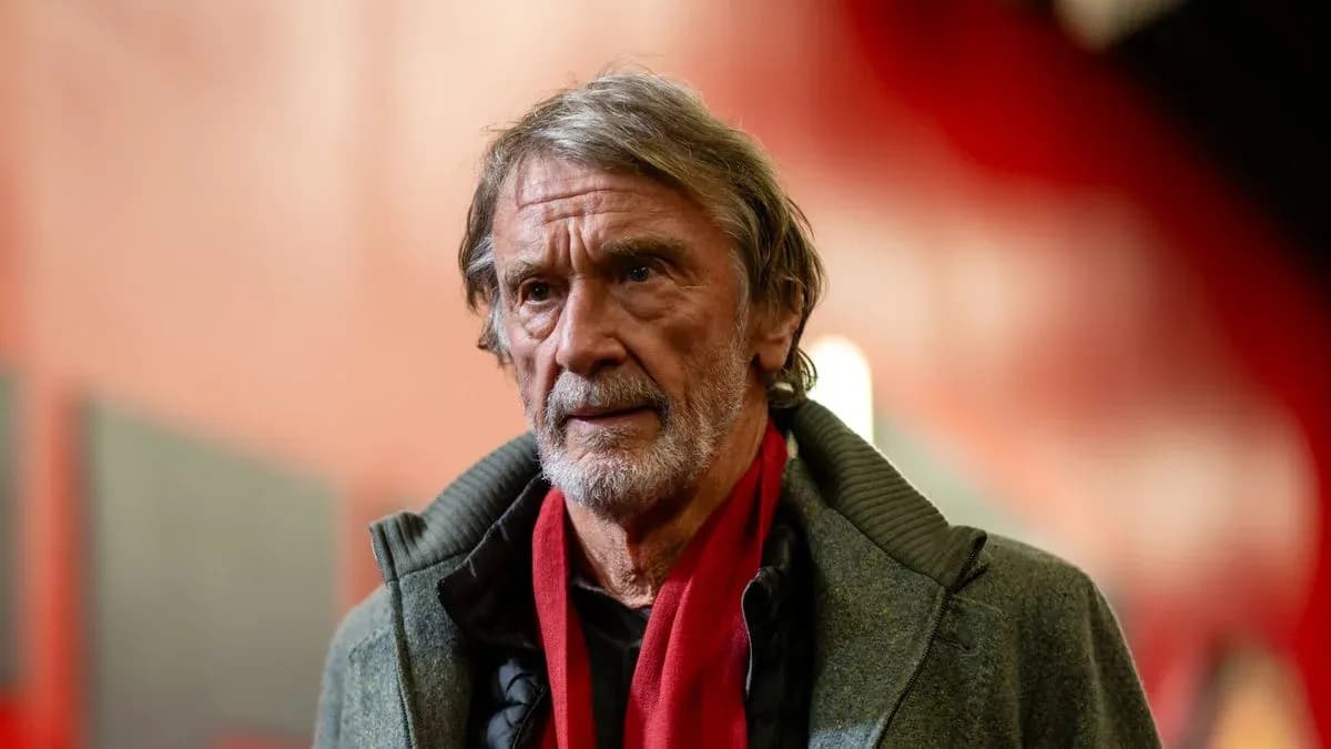 Hombre con abrigo y bufanda roja en un pasillo