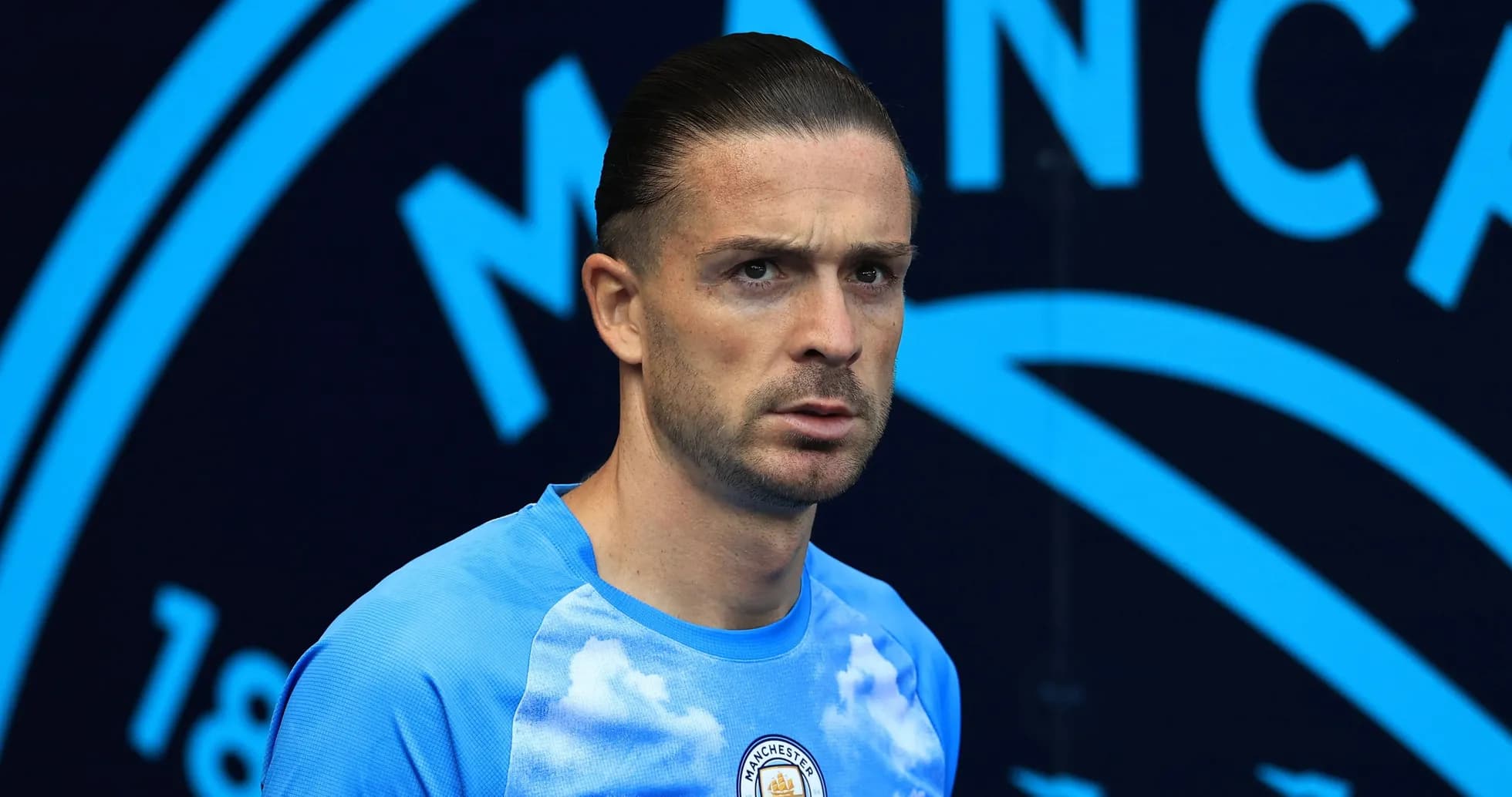 Jugador de Manchester City en camiseta azul con nubes