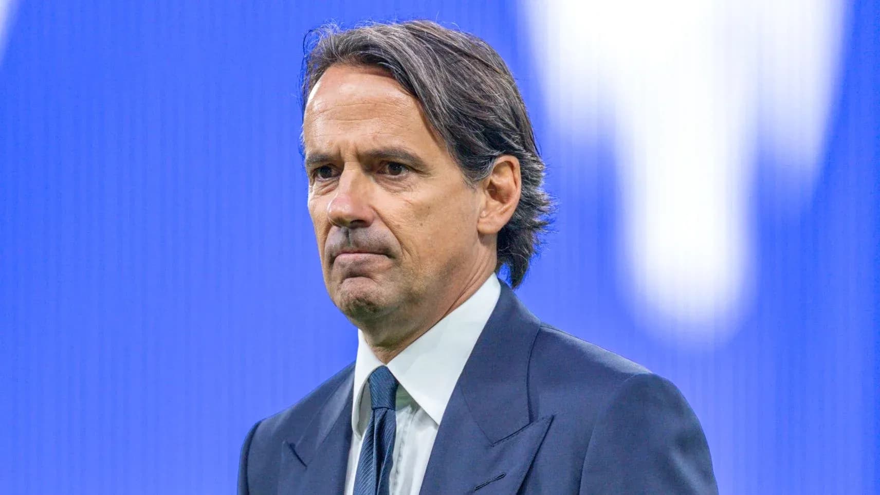 Entrenador en conferencia de prensa con fondo azul
