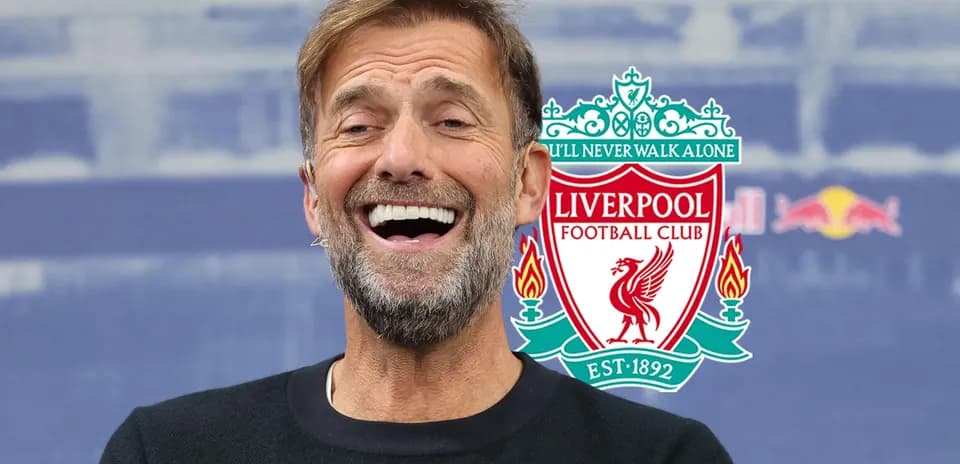 Entrenador sonriente con logo de Liverpool de fondo