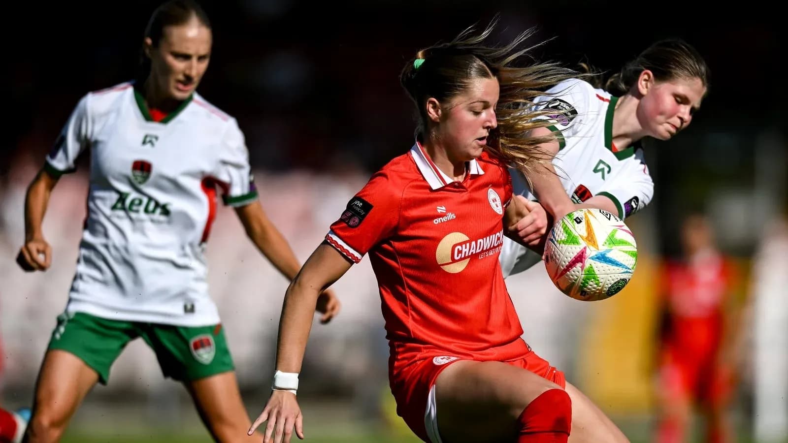 Jugadora en rojo controlando el balón en el partido
