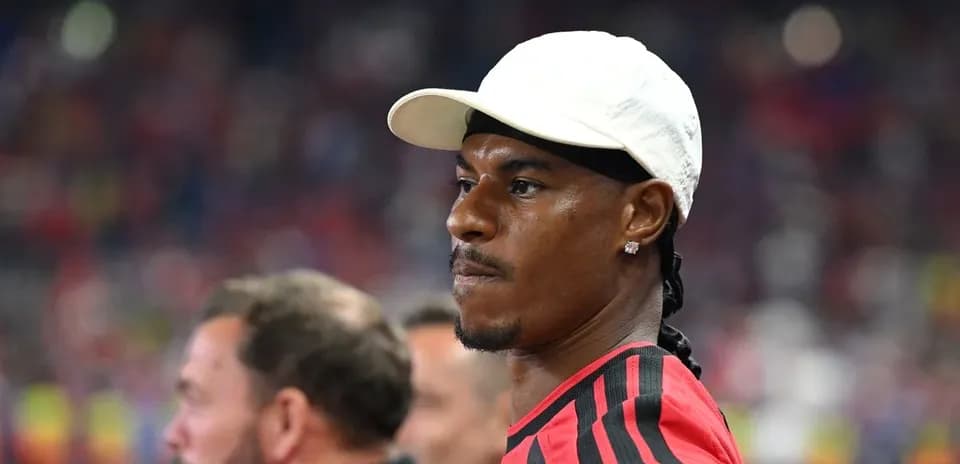 Jugador con gorra observando el partido en el estadio