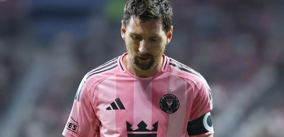 Jugador con camiseta rosa caminando en el campo