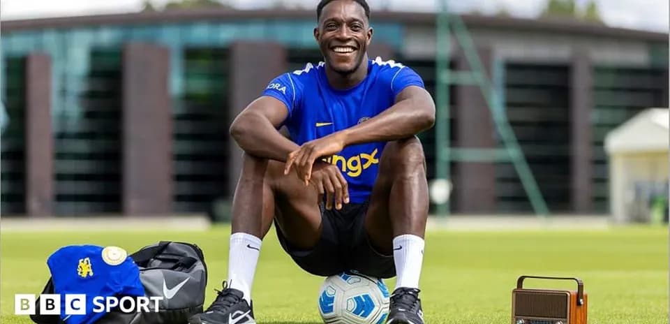 Jugador sonriente sentado en el campo de entrenamiento