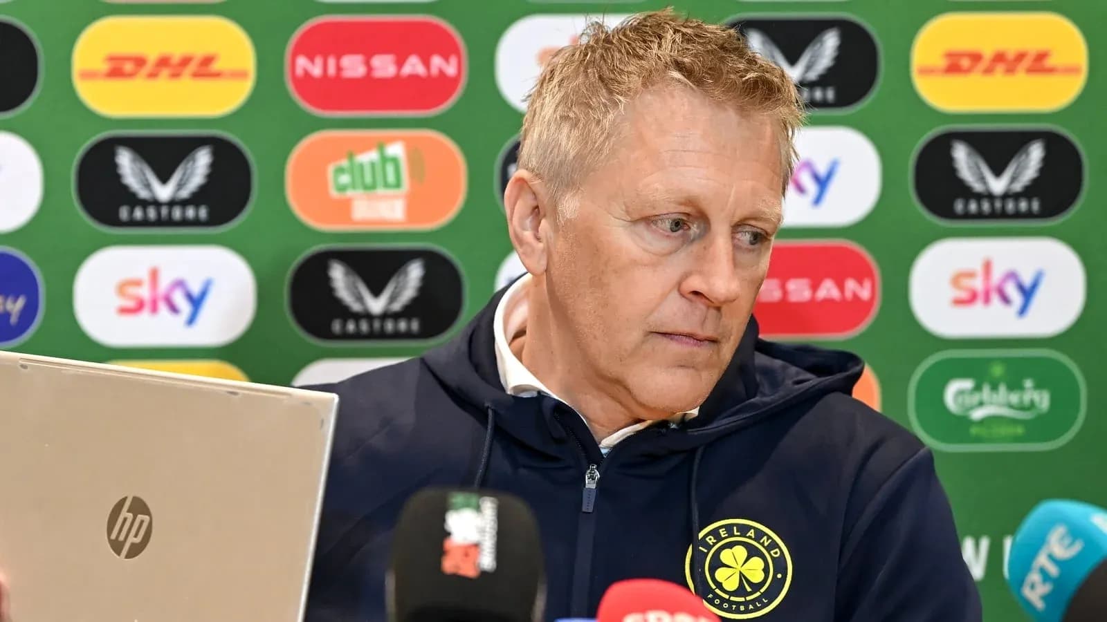 Entrenador en conferencia de prensa con computadora portátil