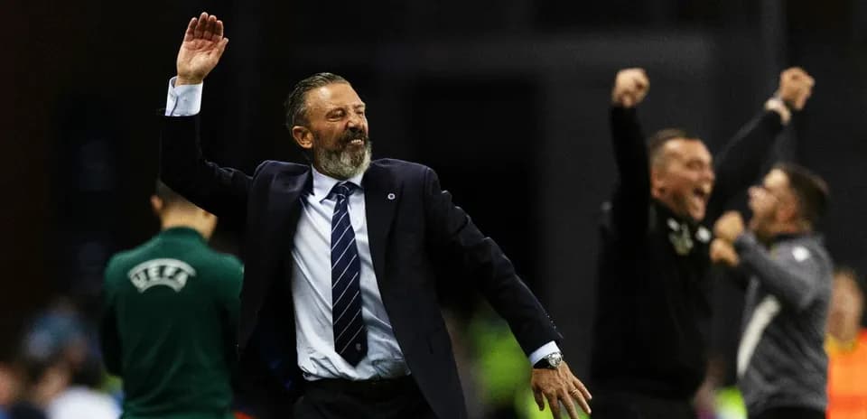 Entrenador celebrando con los brazos en alto