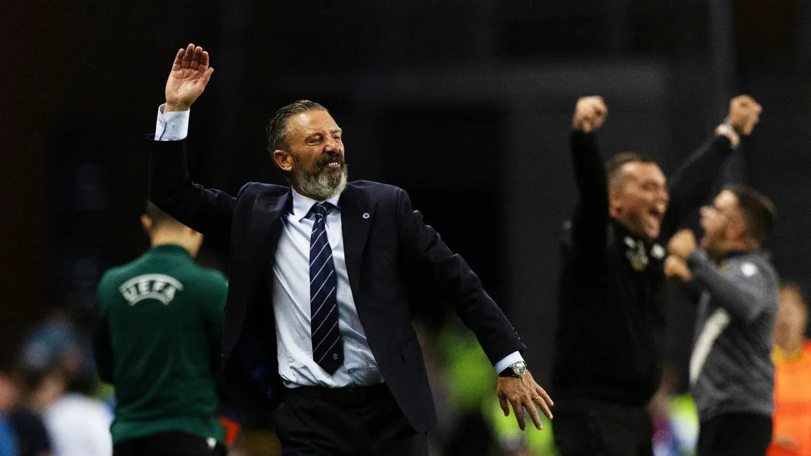 Entrenador celebrando con los brazos en alto