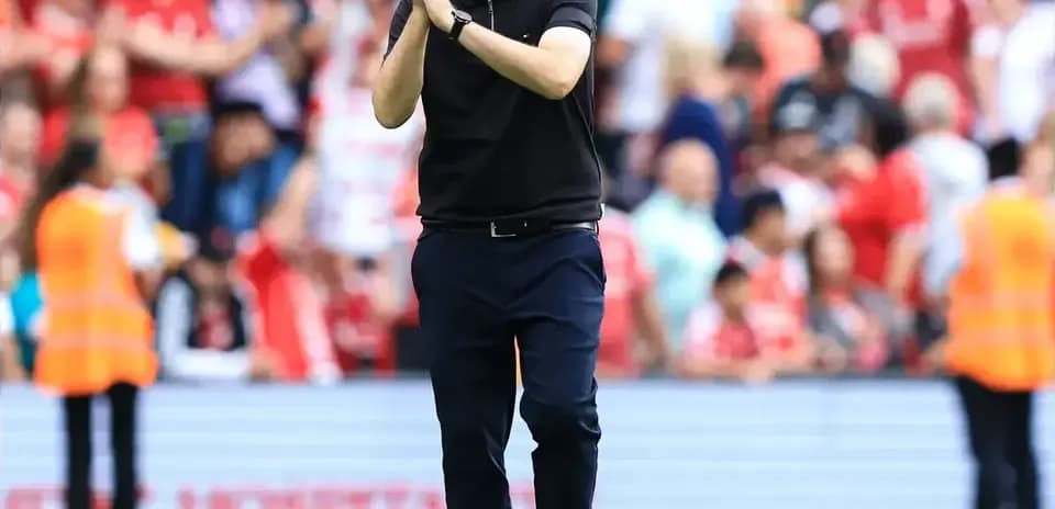 Entrenador aplaudiendo frente a la afición en el estadio