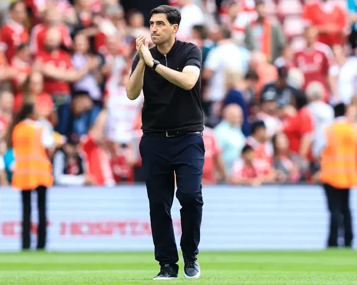 Entrenador aplaudiendo frente a la afición en el estadio