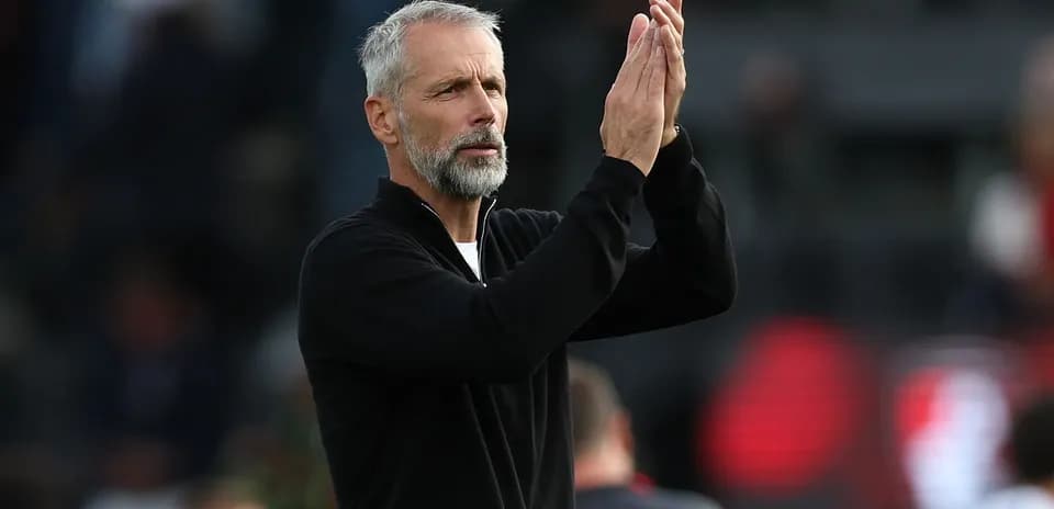 Entrenador aplaudiendo en el campo de fútbol