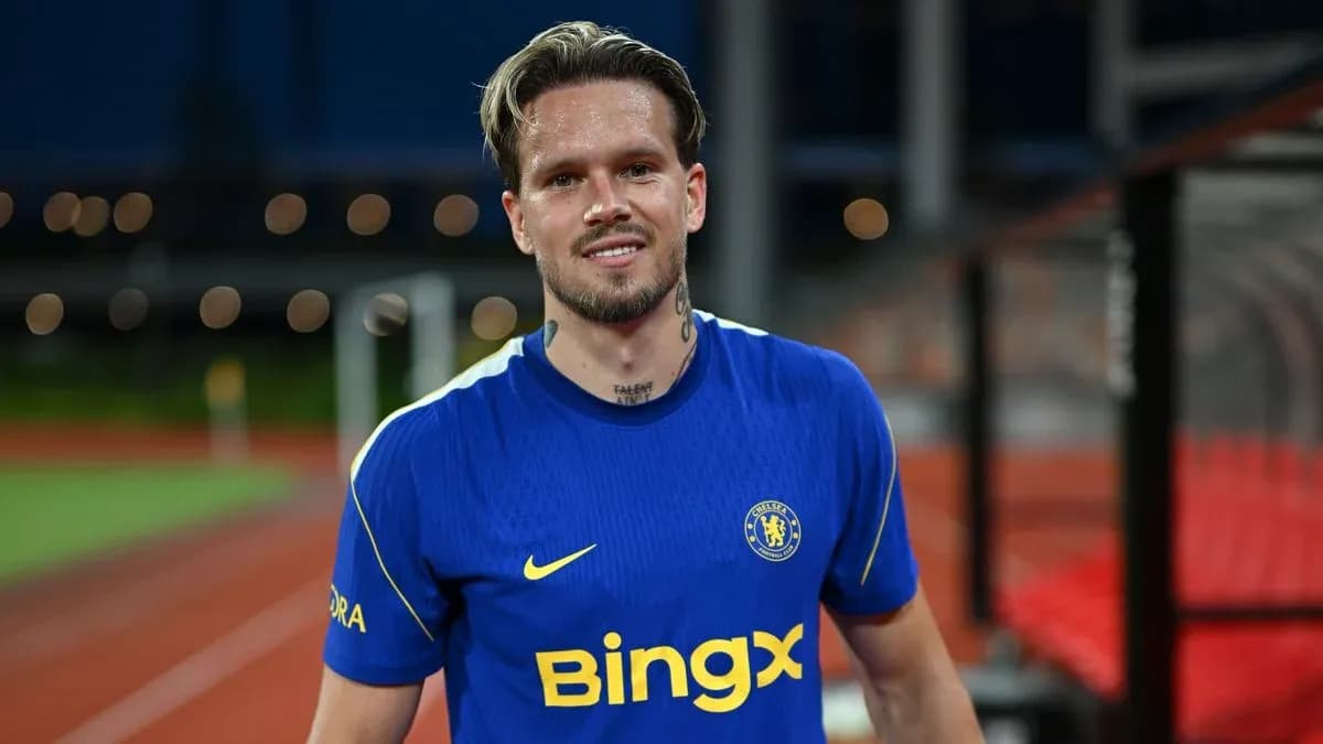 Jugador sonriendo en camiseta del Chelsea en el campo