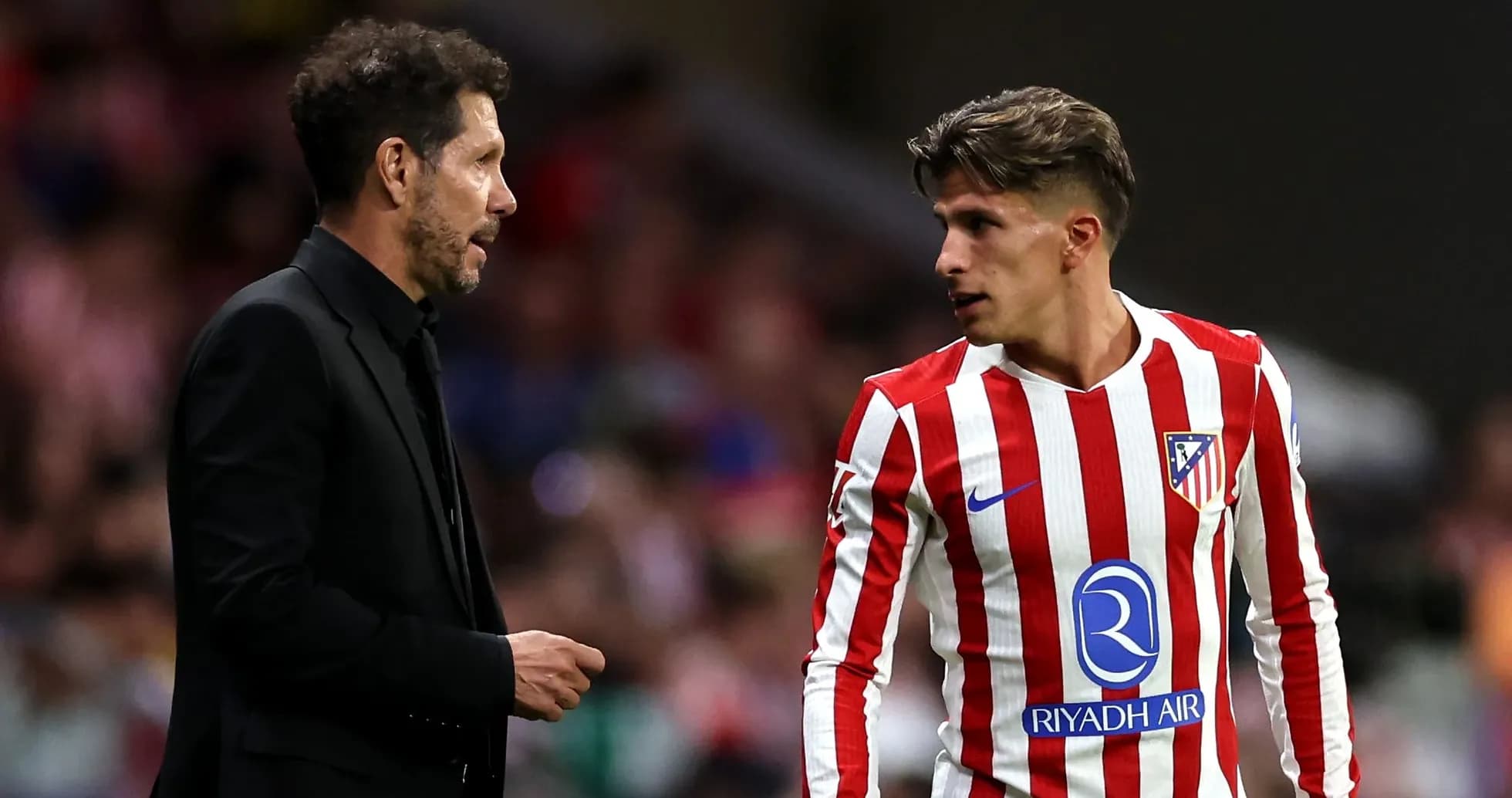 Entrenador hablando con jugador del Atlético de Madrid