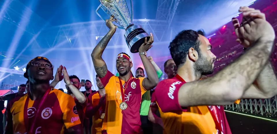 Jugador levantando trofeo con compañeros celebrando
