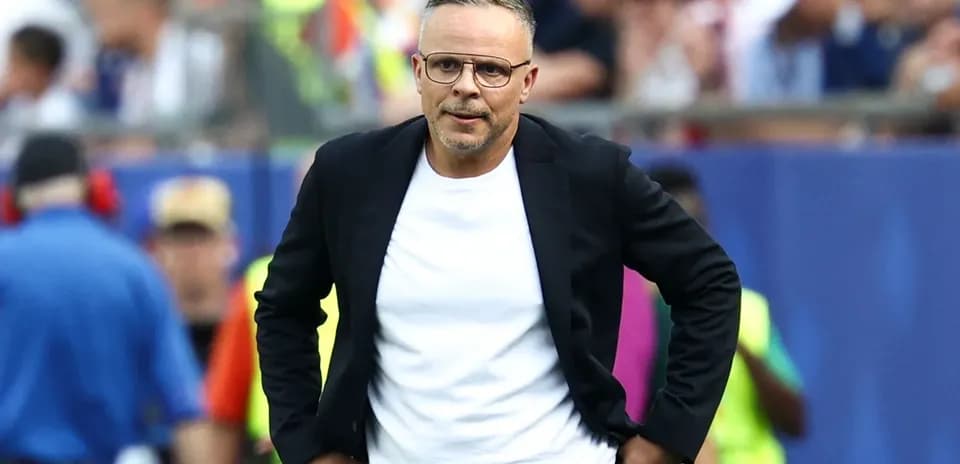 Entrenador caminando en la línea de banda durante el partido