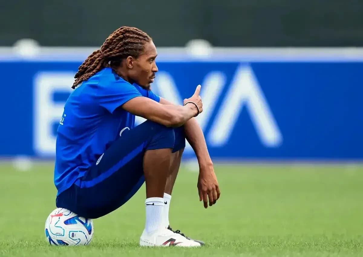 Jugador sentado en el campo con balón de fútbol