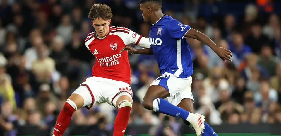 Jugador de Arsenal desafiando a rival de Ipswich