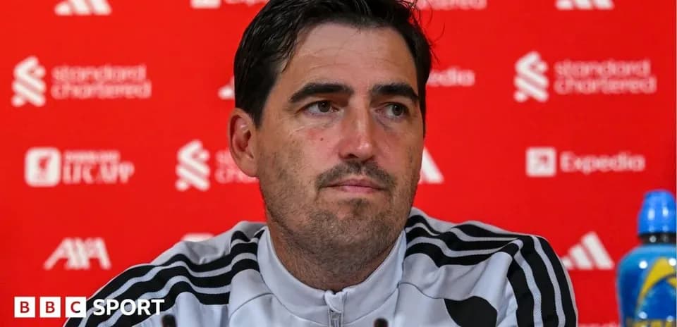 Entrenador en conferencia de prensa ante fondo rojo
