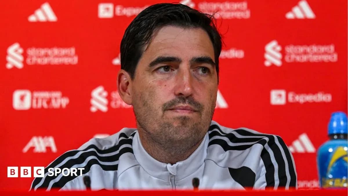 Entrenador en conferencia de prensa ante fondo rojo