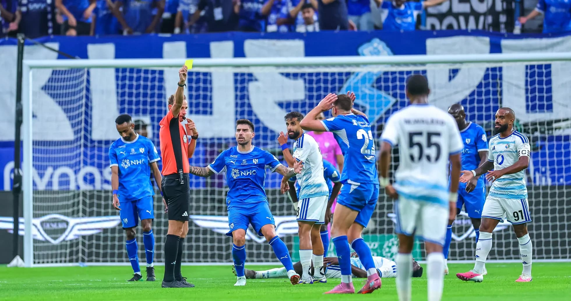 Árbitro mostrando tarjeta amarilla a jugador en partido