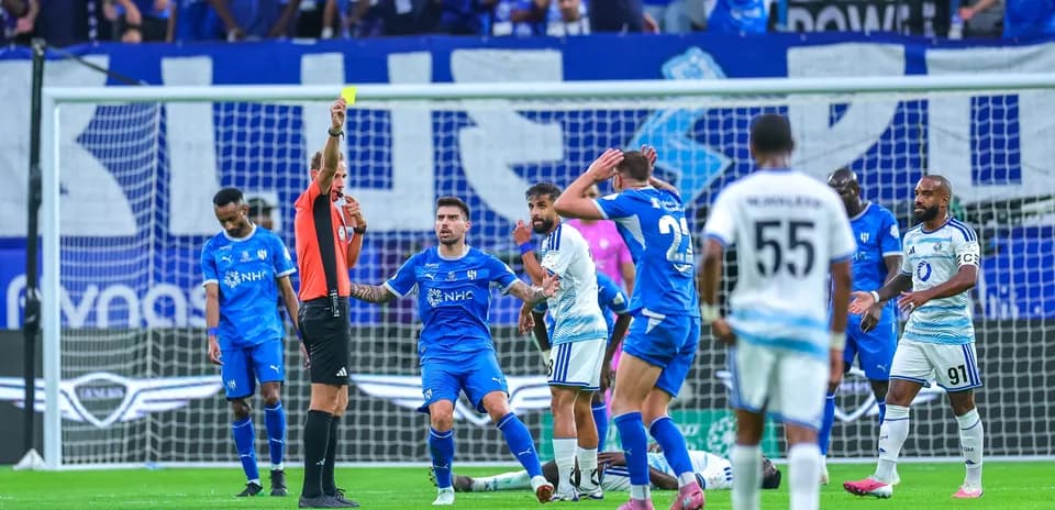 Árbitro mostrando tarjeta amarilla a jugador en partido