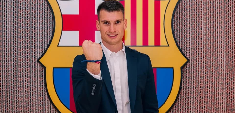 Jugador mostrando puño frente al escudo del Barcelona
