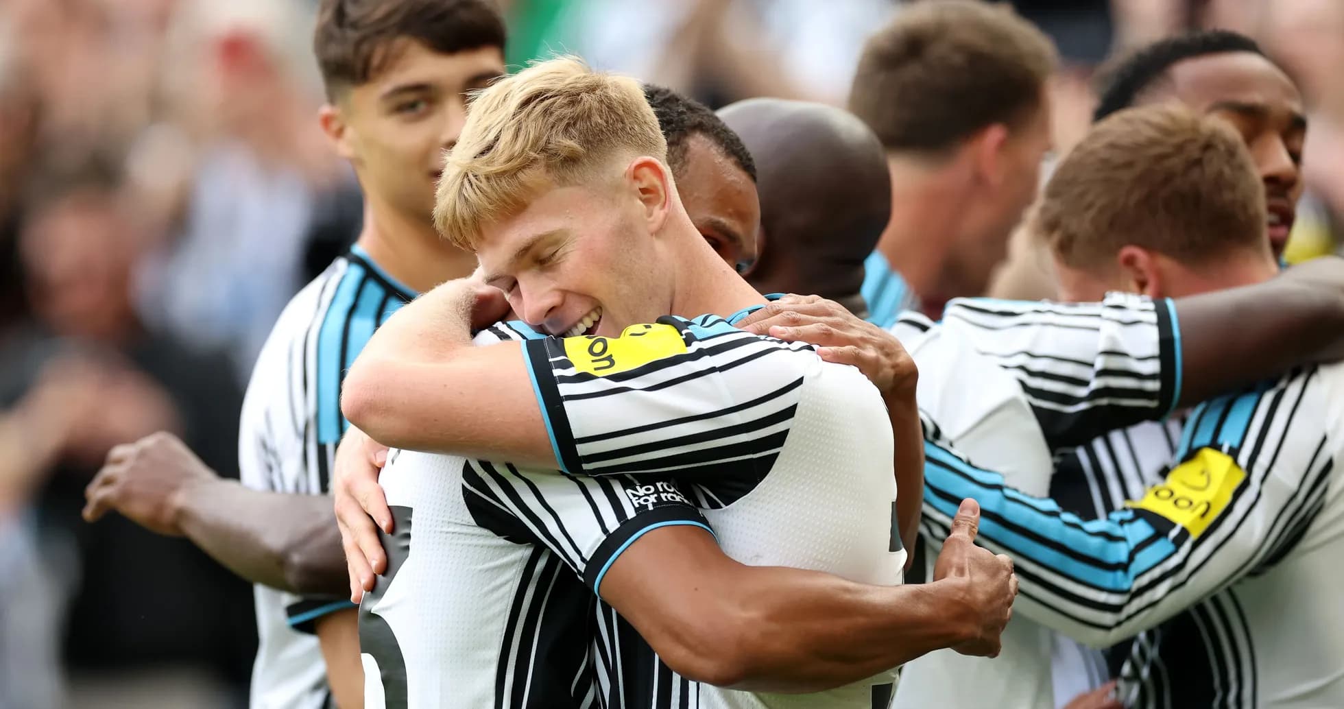 Jugadores de Newcastle United celebrando un gol abrazados