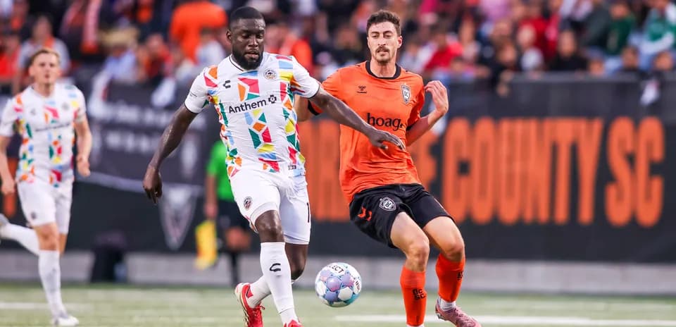 Jugador con camiseta colorida corriendo con el balón