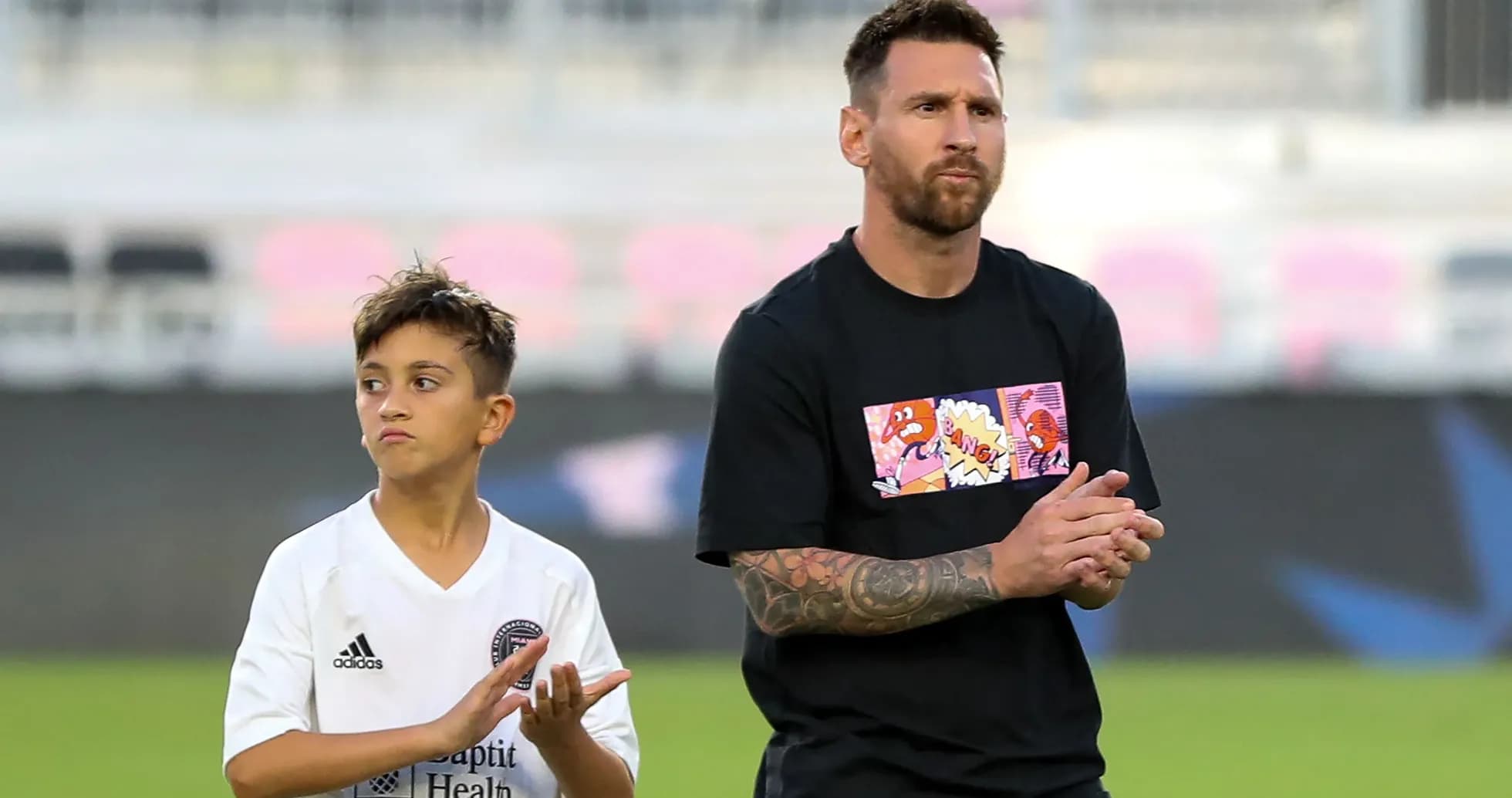 Lionel Messi y un niño aplaudiendo en el campo