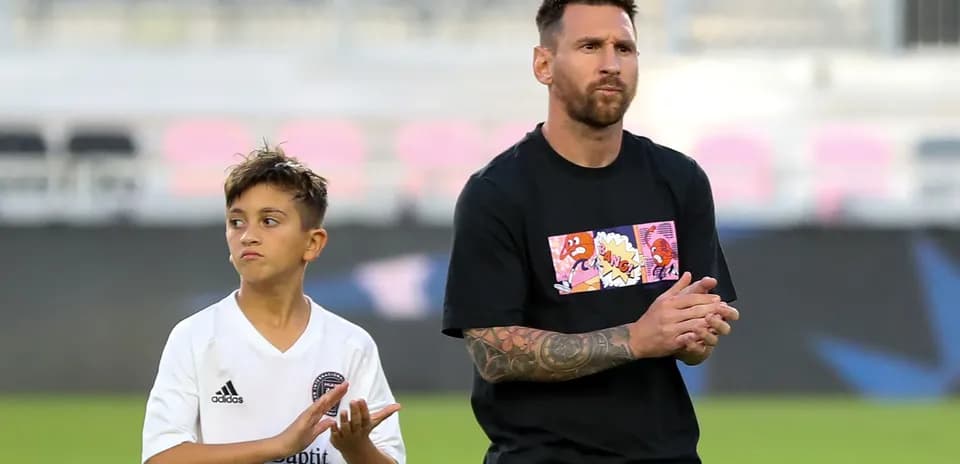 Lionel Messi y un niño aplaudiendo en el campo