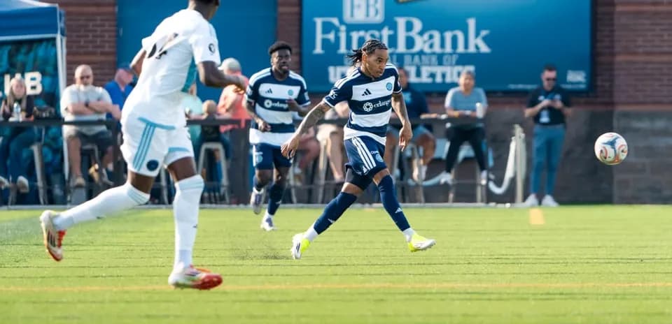 Jugador corriendo con el balón en el campo