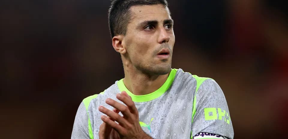 Jugador aplaudiendo con camiseta gris y detalles verdes