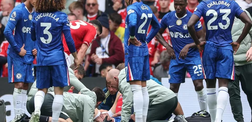 Jugadores de Chelsea rodeando a un compañero herido