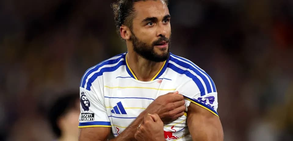 Jugador mostrando el escudo del equipo durante el partido