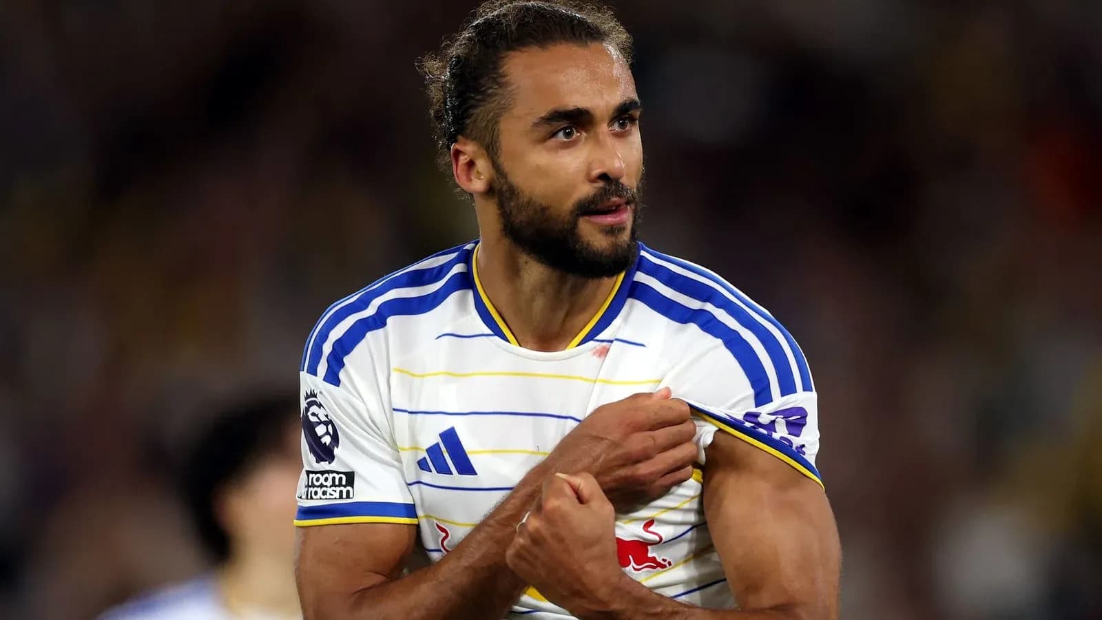 Jugador mostrando el escudo del equipo durante el partido