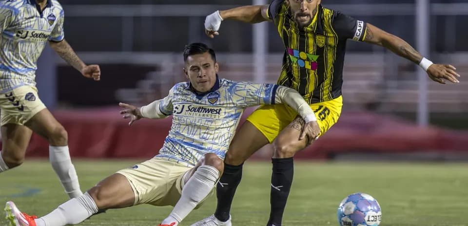 Dos jugadores luchando por el balón en el partido