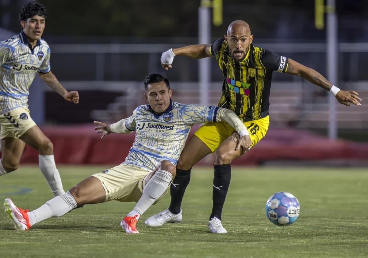 Dos jugadores luchando por el balón en el partido
