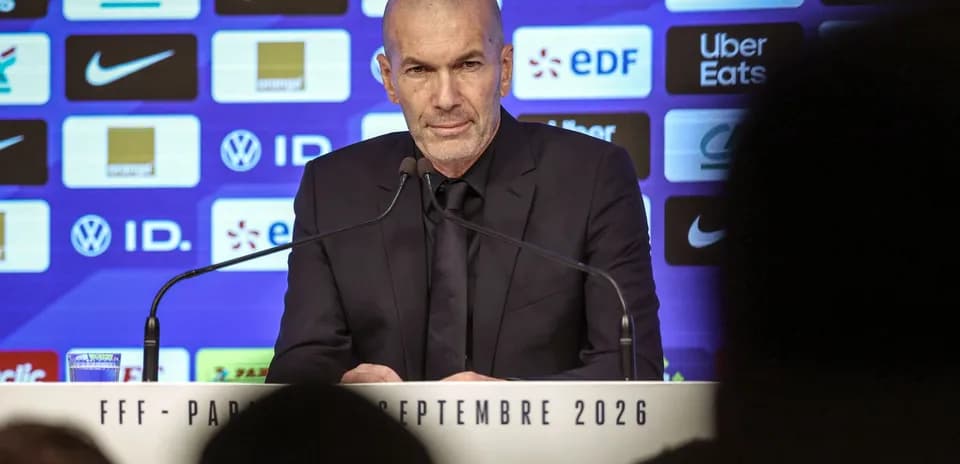 Entrenador en conferencia de prensa con logos detrás