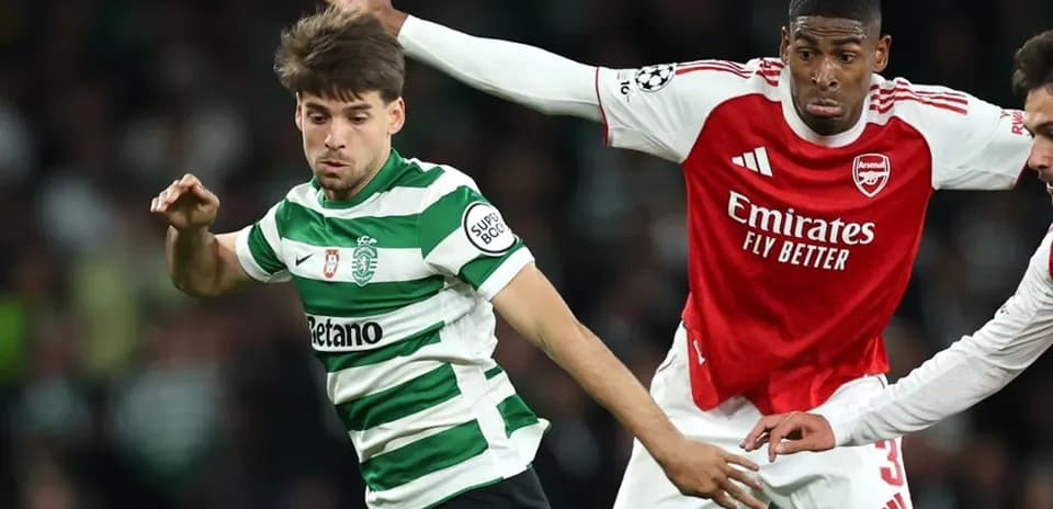 Jugador del Sporting CP esquivando a un defensor del Arsenal
