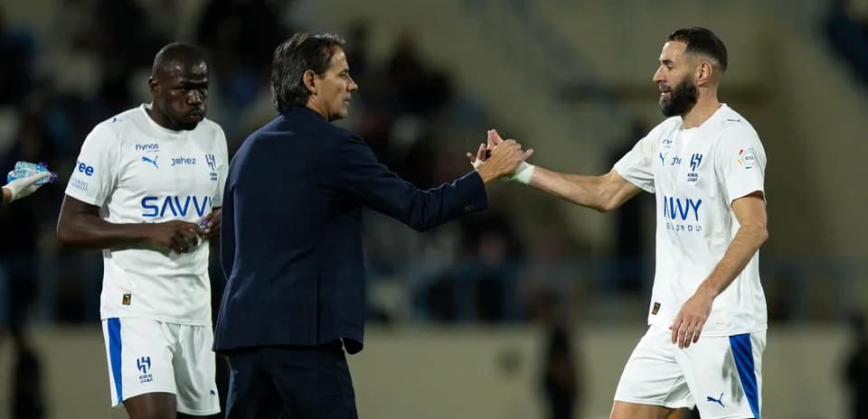 Entrenador saludando a jugador en el banquillo