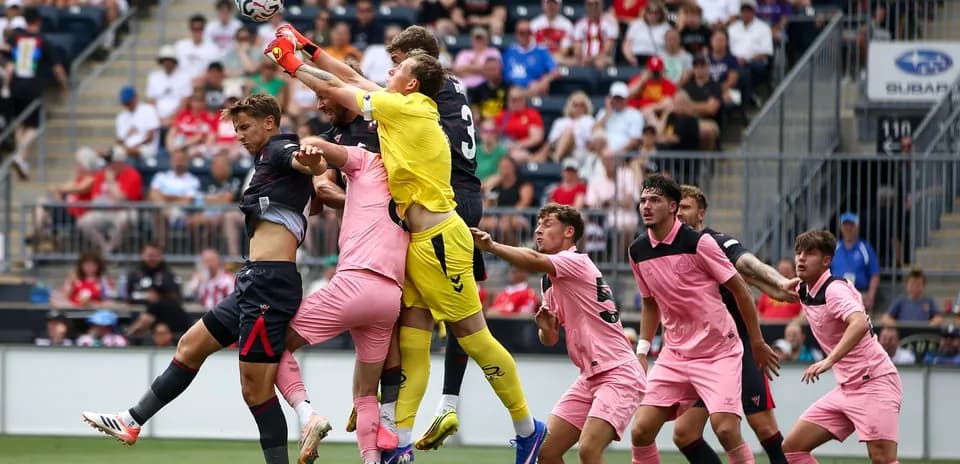 Portero salta para atrapar el balón en el área