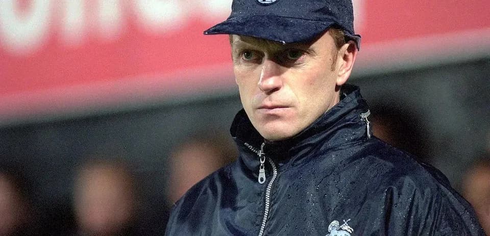 Entrenador de Preston North con abrigo y gorra