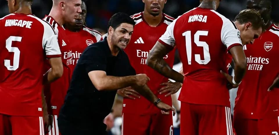 Entrenador explicando estrategia a jugadores de Arsenal