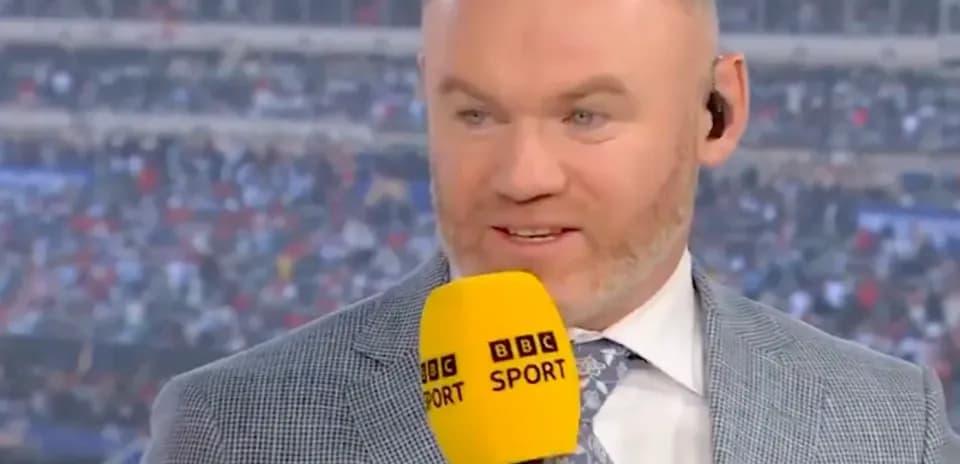 Presentador con micrófono de BBC Sport en fondo de estadio