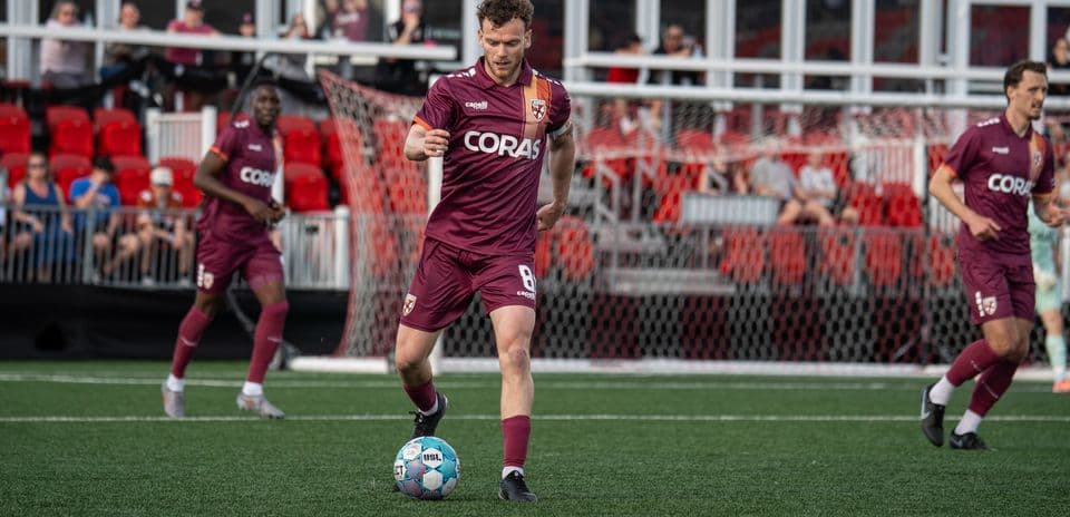 Jugador avanzando con el balón en el partido