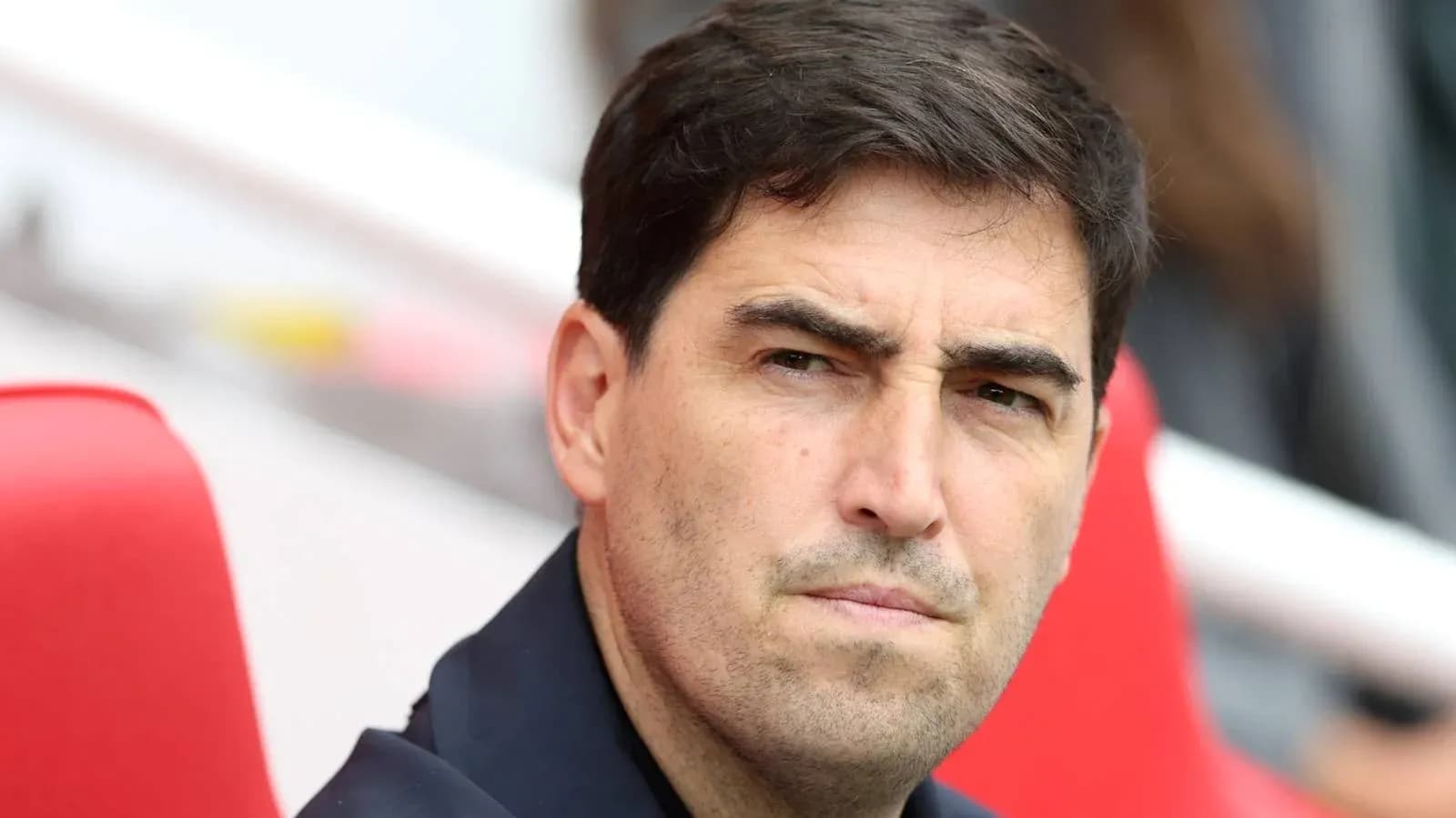 Entrenador observando desde el banquillo durante partido