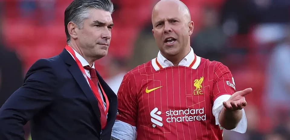 Dos hombres conversando en el estadio de Liverpool