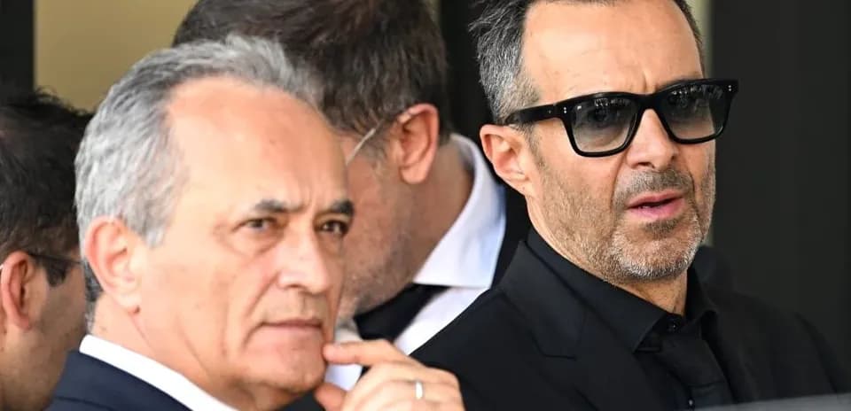 Dos hombres en traje oscuro en evento público