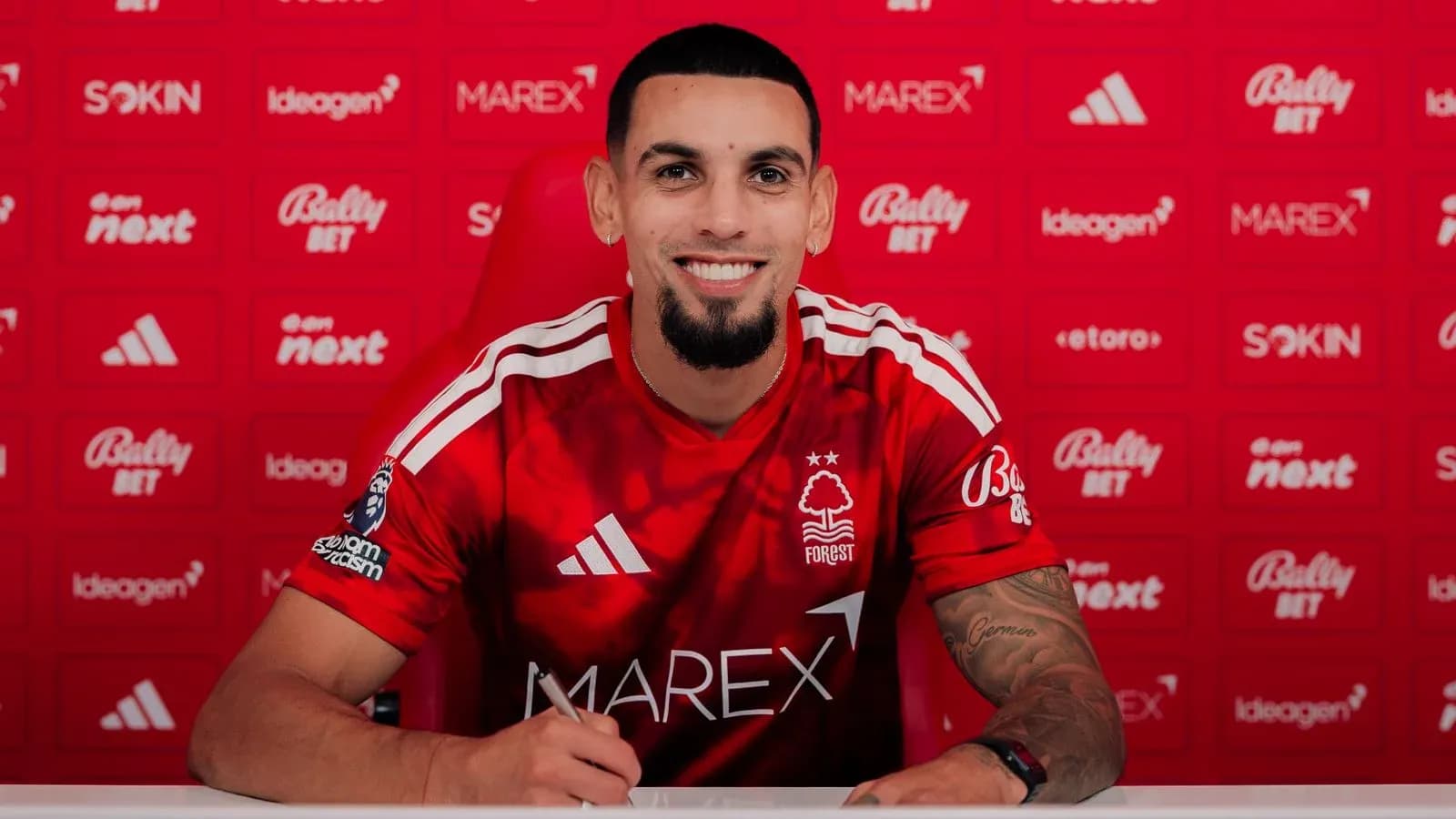 Jugador de Nottingham Forest firmando contrato en mesa