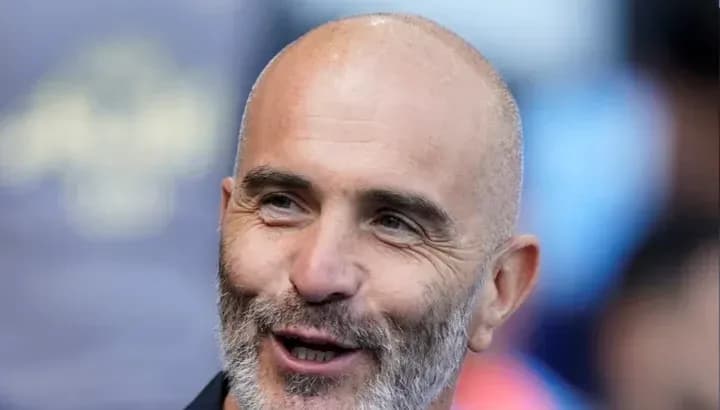 Entrenador sonriente en el banquillo del estadio
