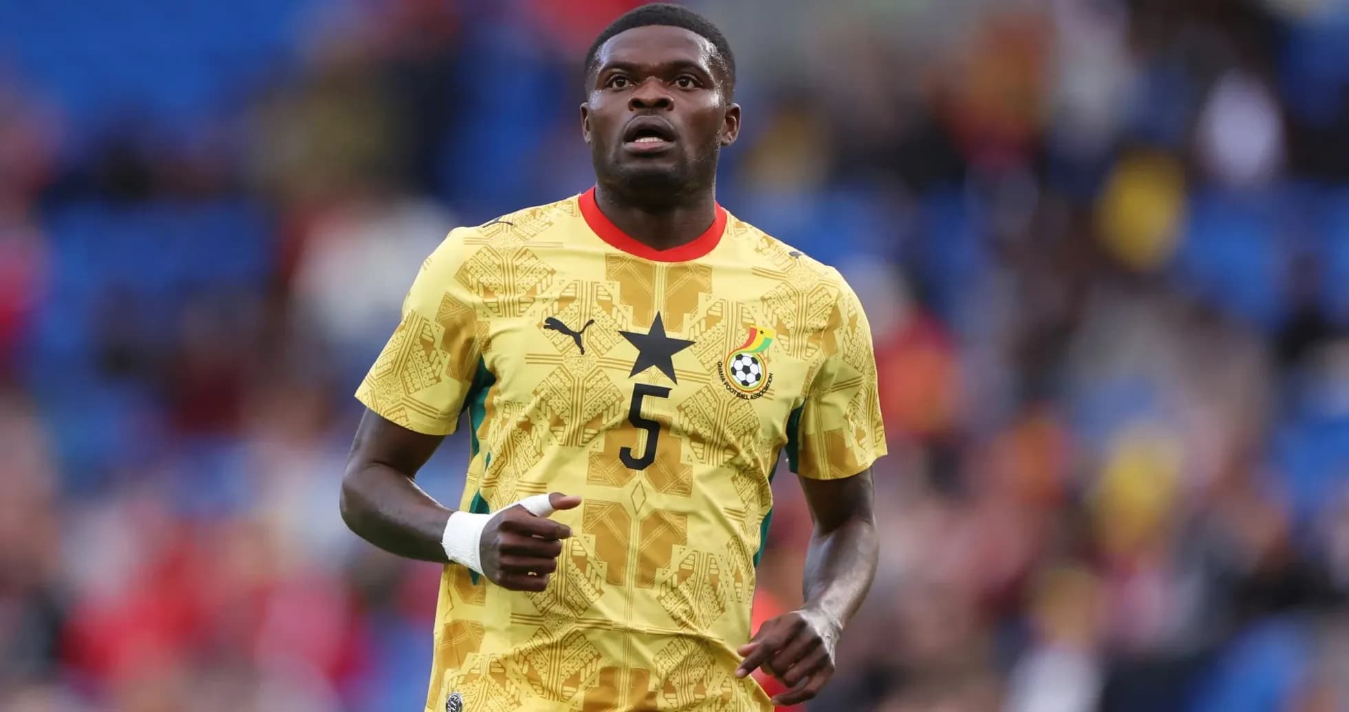 Jugador de Ghana corriendo en uniforme amarillo
